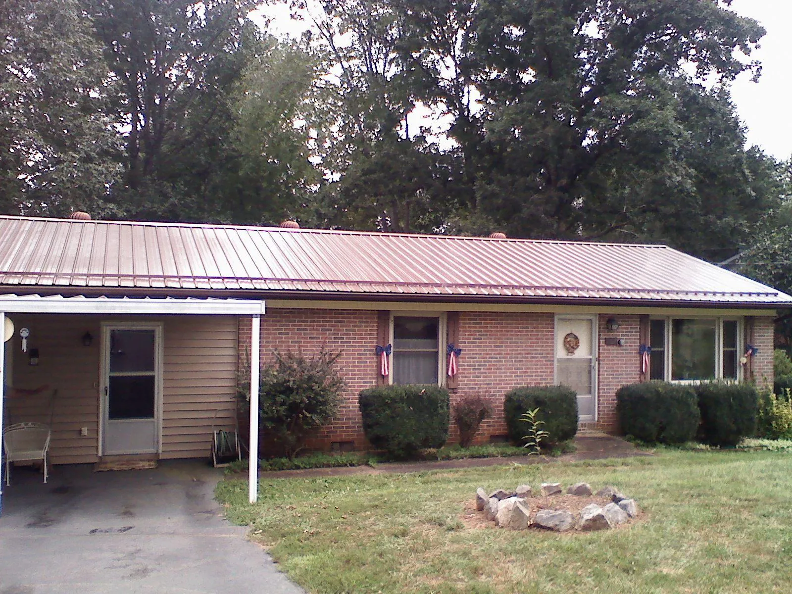 Bronze metal roof and carport on a brick ranch home — Roof Repair work by our crew in Wolf Creek