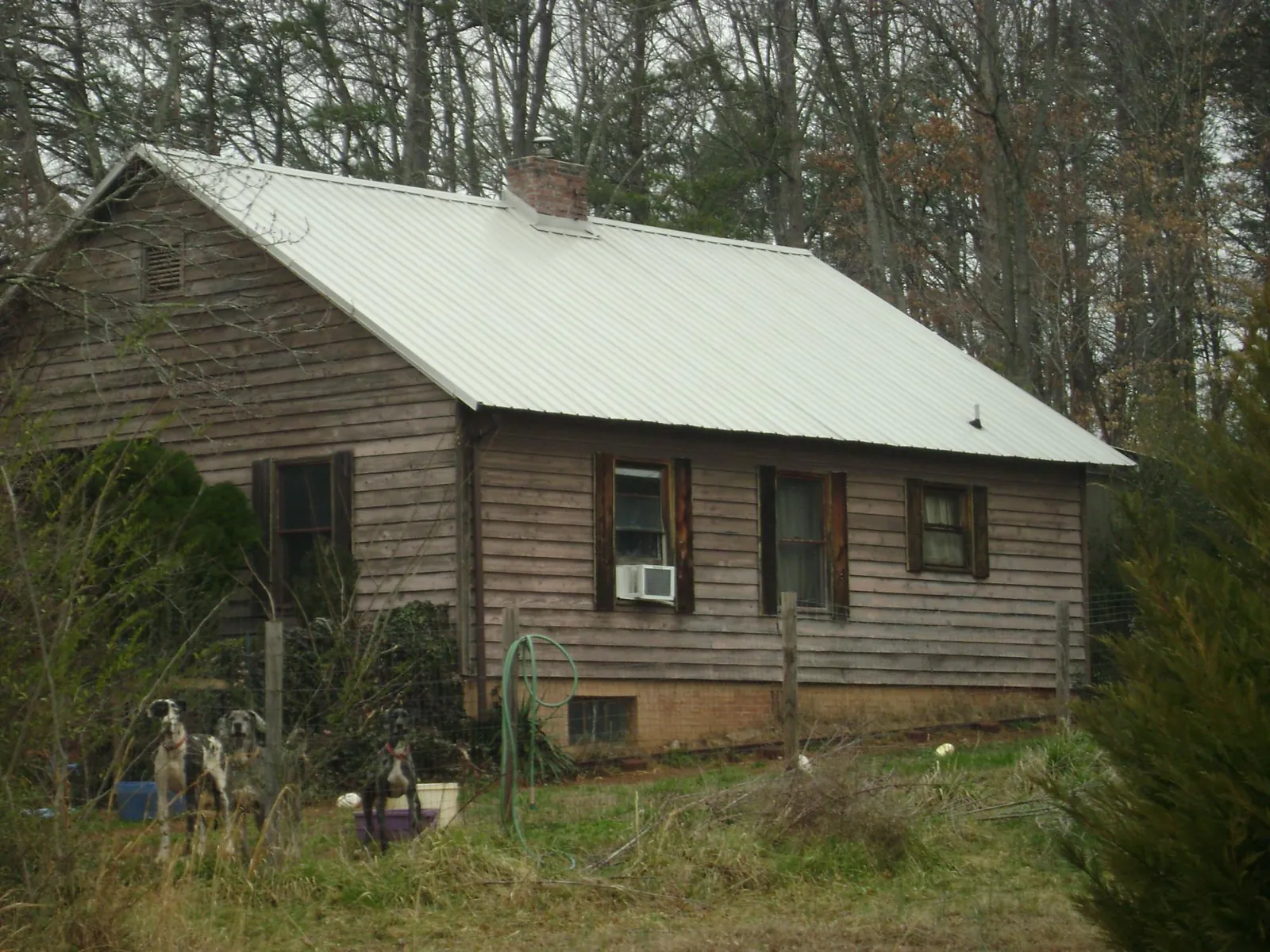 White metal roof on an old wood sided farmhouse, from a Metal Roof Installation job in Wolf Creek